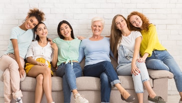 A diverse group of women from different ages sitting together